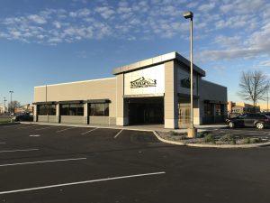 An exterior shot of a building labeled "SouthPoint." The building is tan, gray, and black with a large parking lot surrounding it.