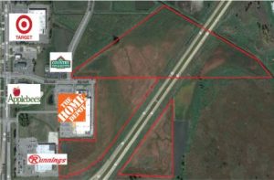 An aerial shot of a highway. Along the highway are multiple areas boxed off with red borders. On the left side of the image are logos for the following stores: Target, Country Inn & Suites, Applebee's, The Hope Depot, and Runnings.