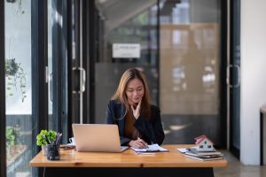 Woman working at desk in business, planning sale